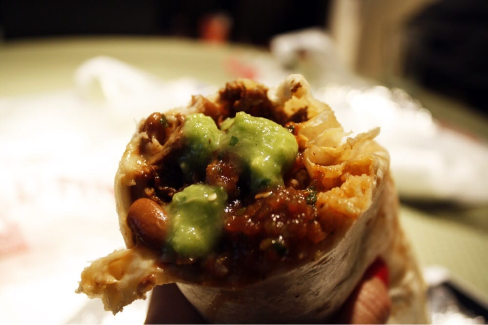 Burrito cross-section showing guacamole, pinto beans, rice, and seasoned meat