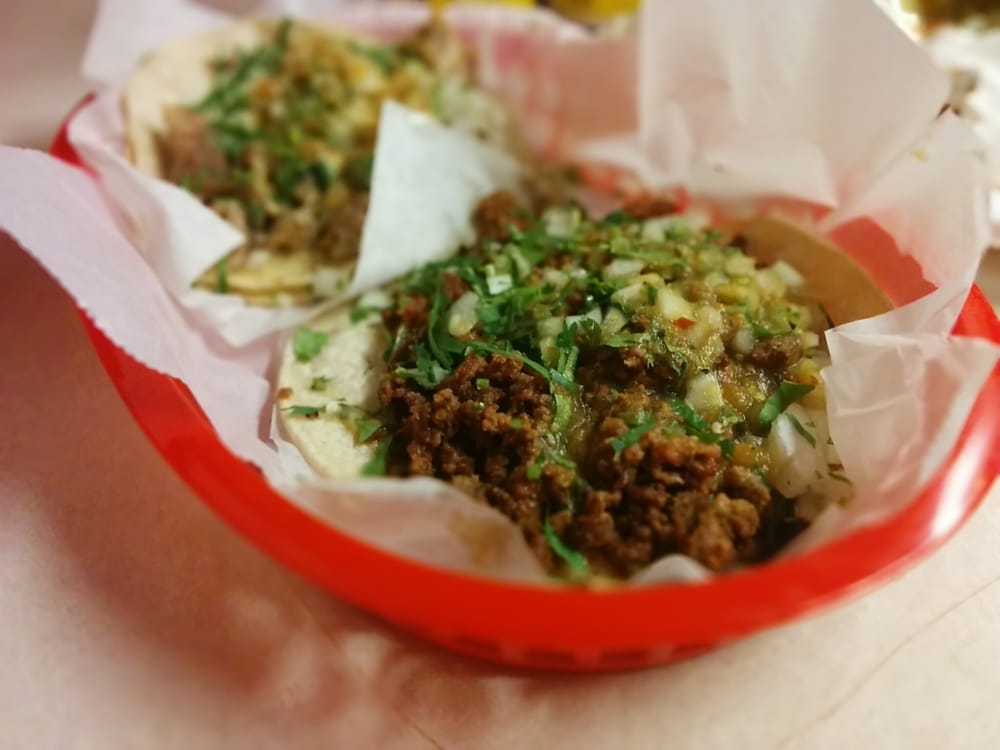 Street-style tacos with seasoned ground beef, cilantro, and onions in a red basket
